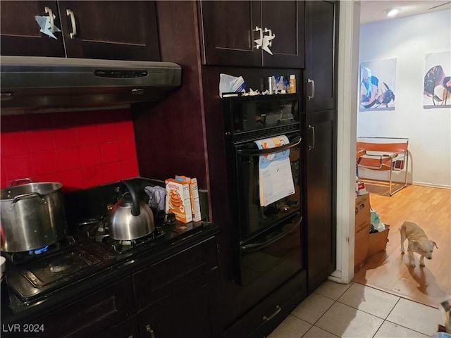 kitchen featuring oven, decorative backsplash, and light tile patterned floors