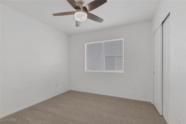 empty room featuring ceiling fan and light colored carpet