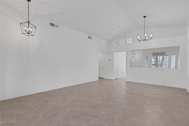 unfurnished living room with a notable chandelier, lofted ceiling, and light tile patterned floors