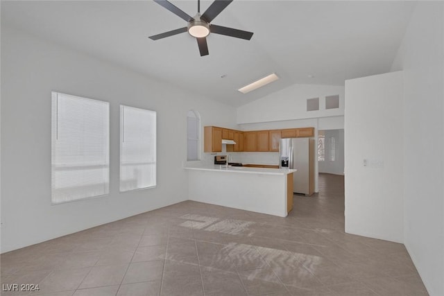 unfurnished living room with light tile patterned floors, high vaulted ceiling, and ceiling fan