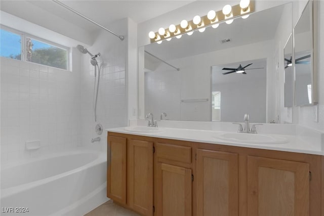 bathroom featuring tile patterned flooring, tiled shower / bath, vanity, and ceiling fan