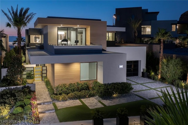 view of front of property featuring a balcony and a garage