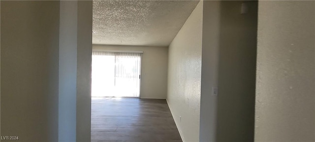 hallway featuring wood-type flooring and a textured ceiling