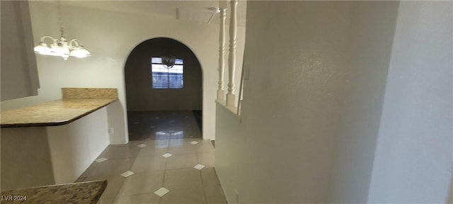 corridor featuring light tile patterned floors and a chandelier