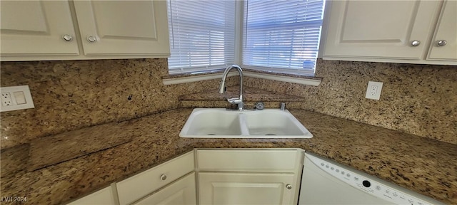 kitchen featuring white dishwasher, decorative backsplash, white cabinetry, and sink