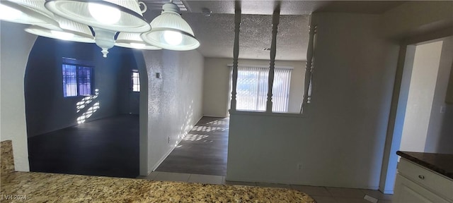 unfurnished dining area featuring hardwood / wood-style floors and a textured ceiling