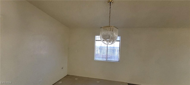 unfurnished dining area featuring a notable chandelier and vaulted ceiling