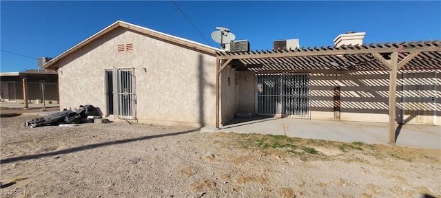 back of house featuring central AC unit and a pergola