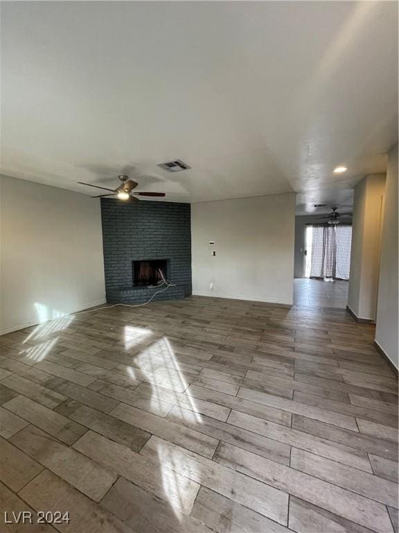 unfurnished living room with a fireplace and ceiling fan