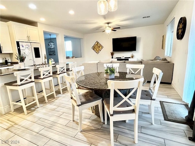 dining area with ceiling fan and light hardwood / wood-style floors