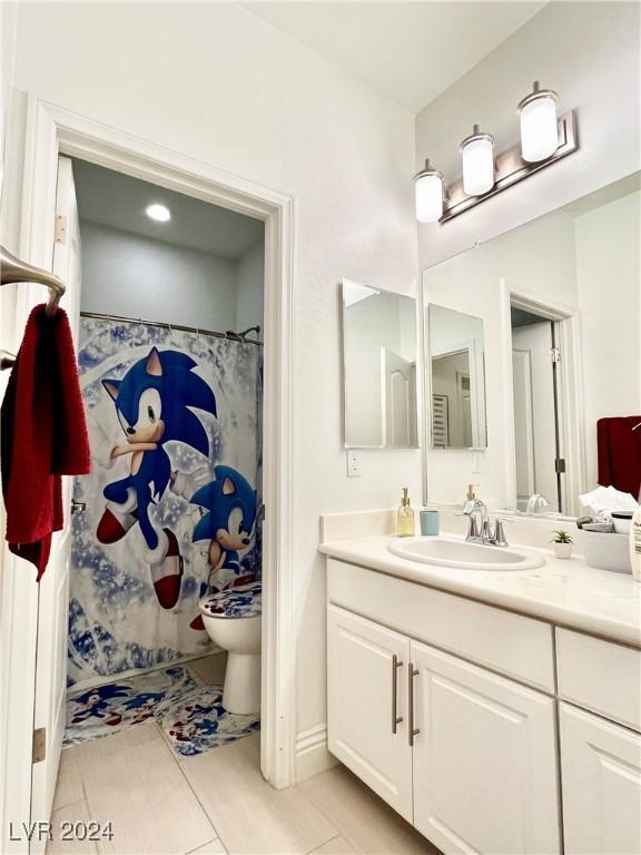 bathroom featuring tile patterned floors, vanity, toilet, and walk in shower