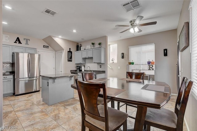 tiled dining area with ceiling fan