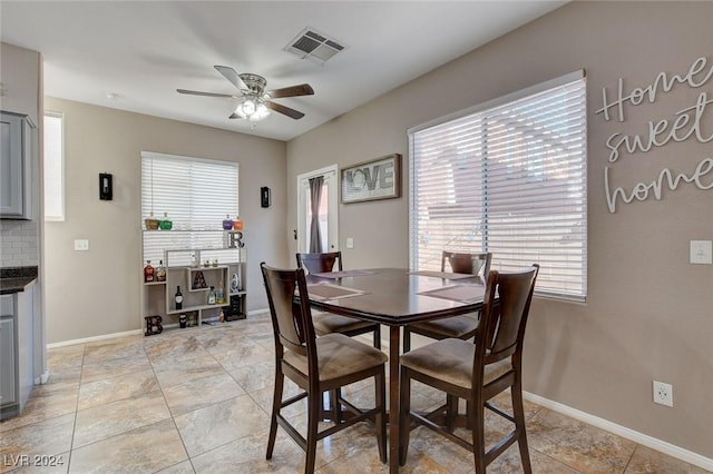 tiled dining space with ceiling fan