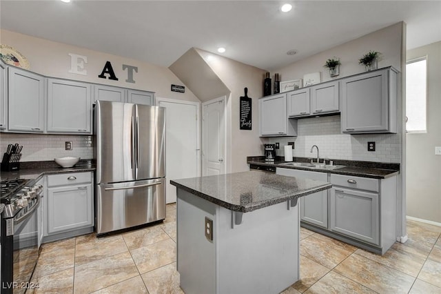 kitchen featuring gray cabinetry, a center island, sink, tasteful backsplash, and stainless steel appliances