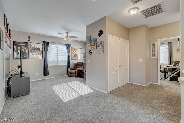 living area with carpet floors, plenty of natural light, and ceiling fan