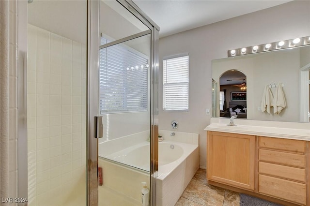 bathroom with tile patterned flooring, vanity, and plus walk in shower