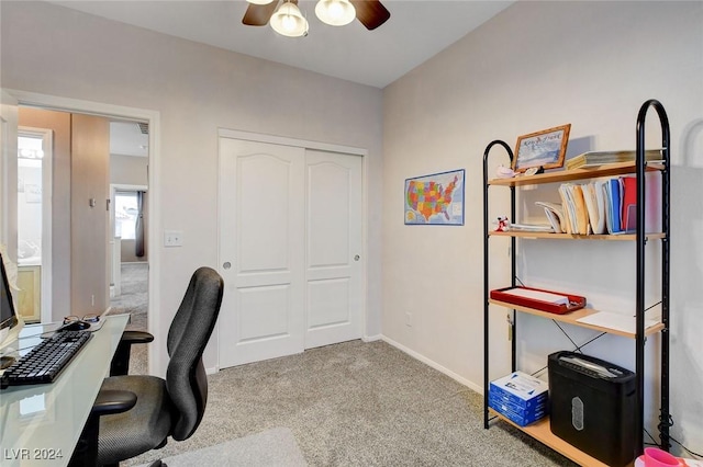 carpeted home office featuring ceiling fan