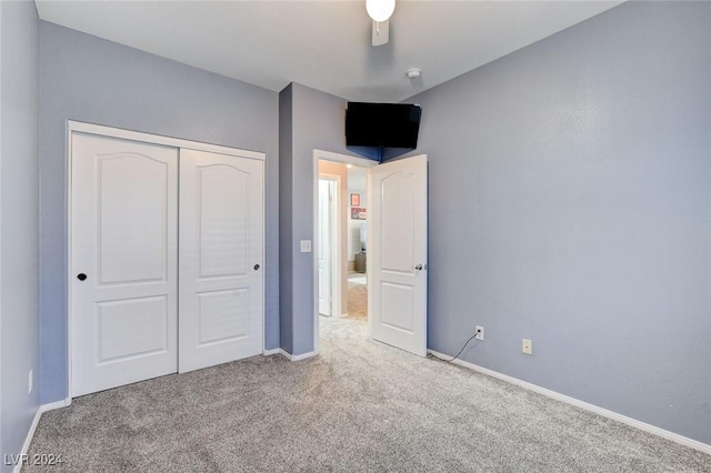 unfurnished bedroom with carpet flooring, a closet, and ceiling fan