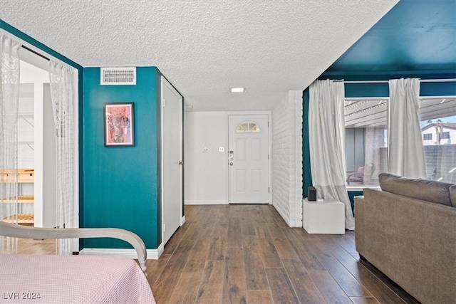 foyer with a textured ceiling and dark wood-type flooring