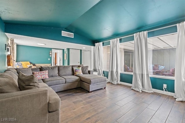 living room featuring vaulted ceiling and hardwood / wood-style flooring