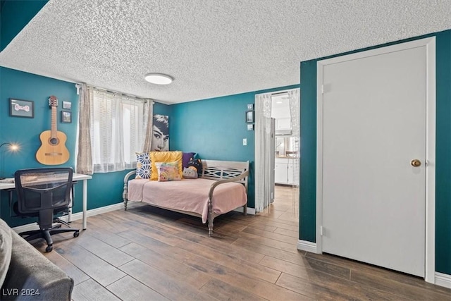 bedroom with a textured ceiling and hardwood / wood-style flooring