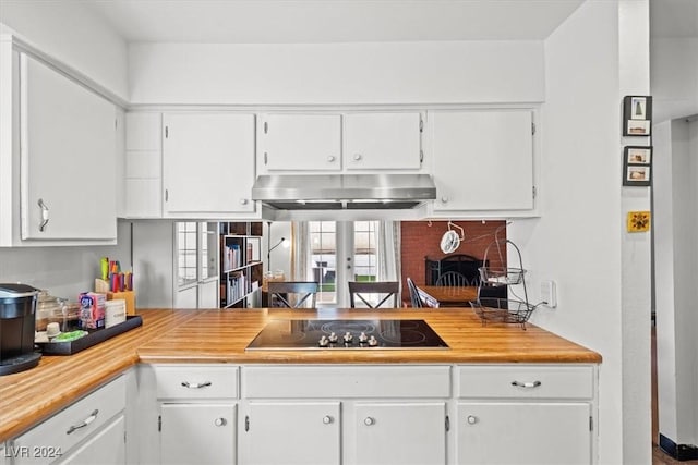 kitchen with black electric stovetop and white cabinets