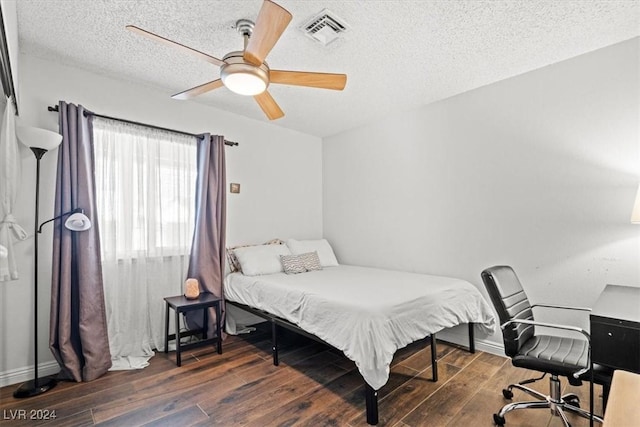 bedroom featuring a textured ceiling, dark hardwood / wood-style floors, and ceiling fan