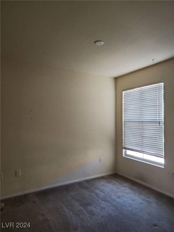 unfurnished room featuring dark carpet