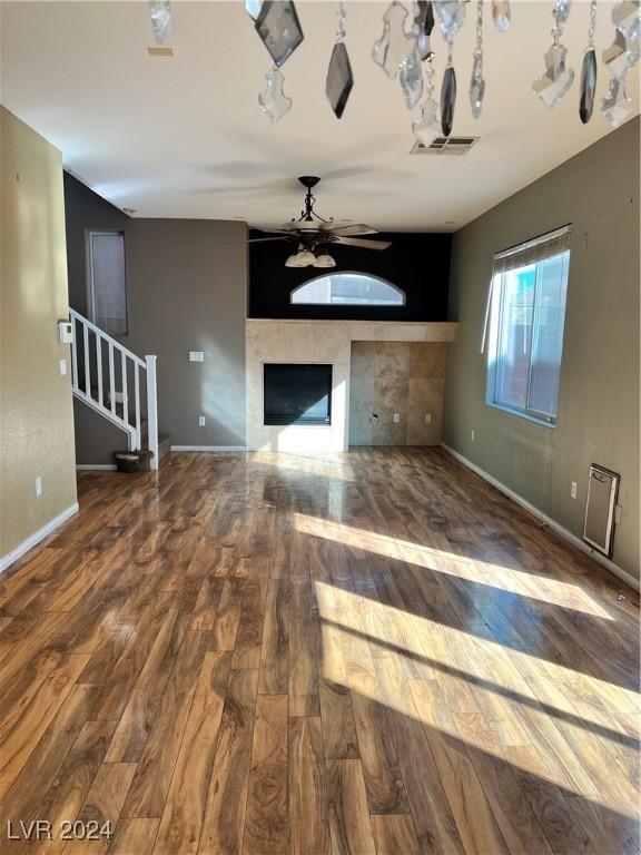 unfurnished living room featuring ceiling fan, a fireplace, and hardwood / wood-style flooring