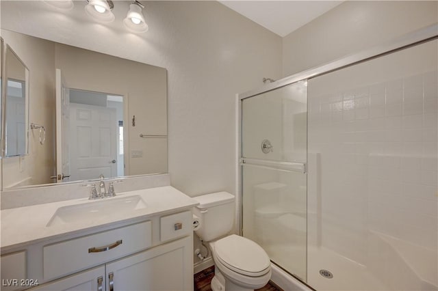 bathroom featuring vanity, toilet, and walk in shower