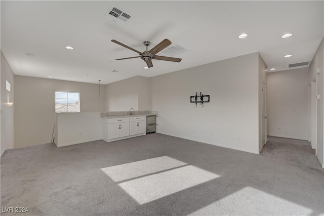 carpeted empty room featuring ceiling fan and sink