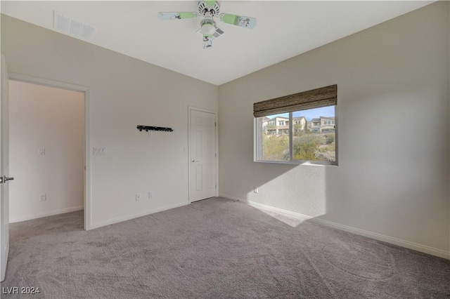 empty room with ceiling fan and light colored carpet