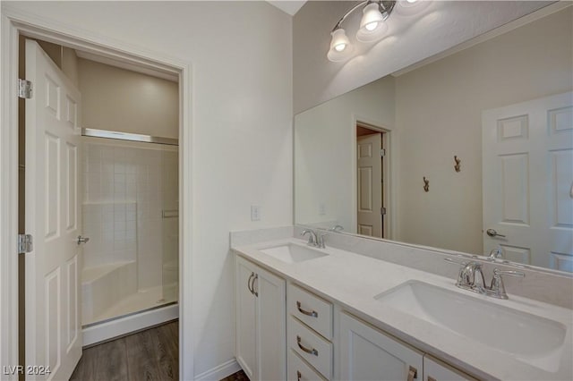 bathroom featuring wood-type flooring, vanity, walk in shower, and a baseboard heating unit