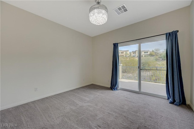 spare room with a notable chandelier and carpet floors