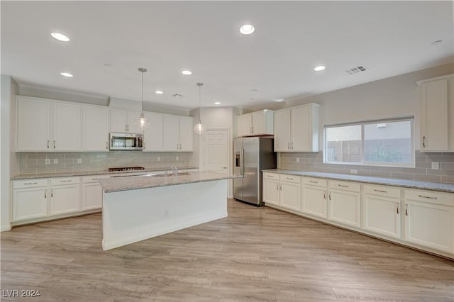 kitchen featuring stainless steel appliances, sink, pendant lighting, light hardwood / wood-style flooring, and white cabinets