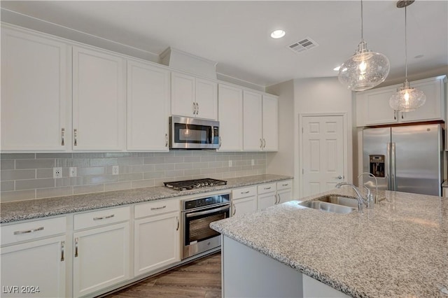 kitchen with white cabinetry, sink, stainless steel appliances, dark hardwood / wood-style flooring, and pendant lighting