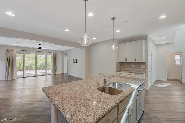 kitchen with ceiling fan, sink, decorative light fixtures, a center island with sink, and white cabinetry