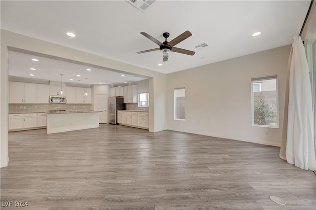 unfurnished living room featuring light hardwood / wood-style floors and ceiling fan