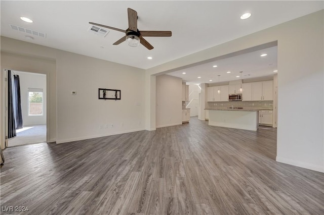 unfurnished living room featuring light hardwood / wood-style floors and ceiling fan