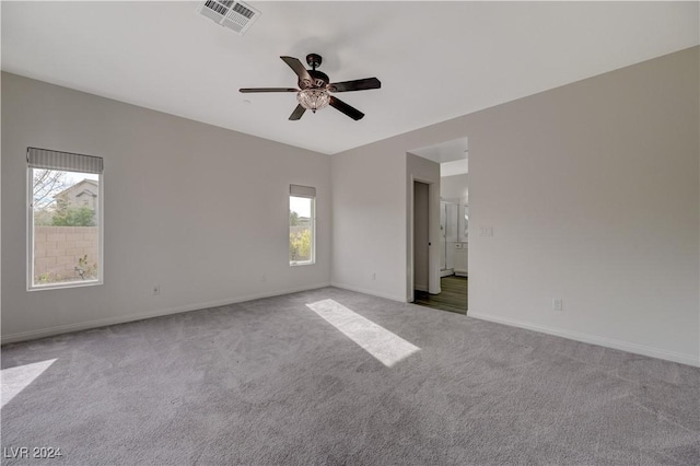 carpeted empty room with a wealth of natural light and ceiling fan