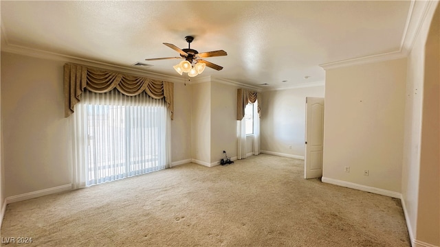 empty room with a textured ceiling, light colored carpet, ceiling fan, and crown molding