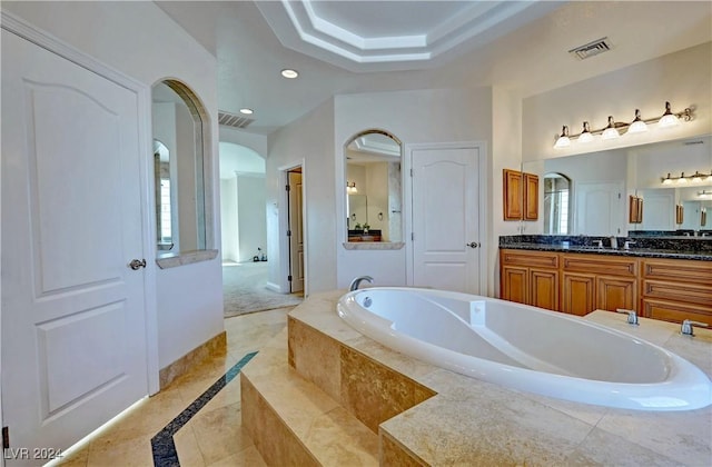 bathroom with vanity and tiled tub