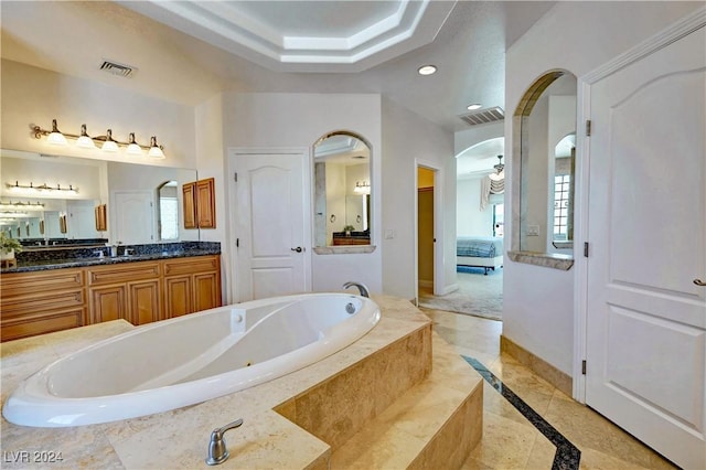 bathroom with vanity, tiled bath, and ceiling fan