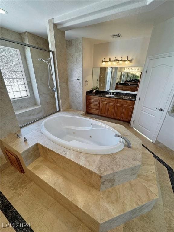 bathroom with vanity and shower with separate bathtub