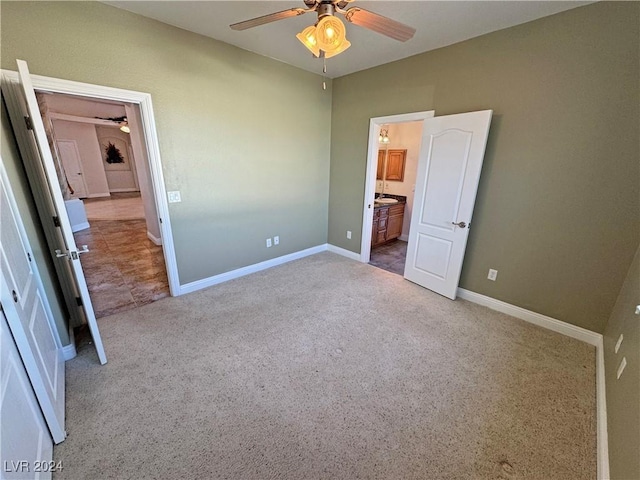 unfurnished bedroom featuring light carpet, connected bathroom, and ceiling fan