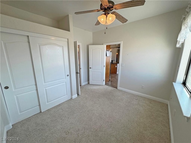 unfurnished bedroom featuring ceiling fan, light colored carpet, and a closet