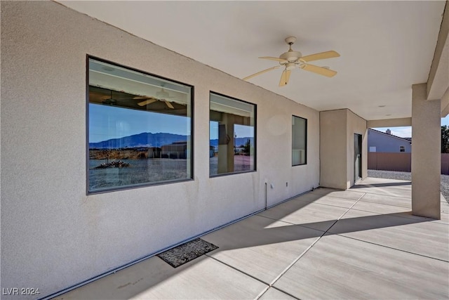 view of patio with ceiling fan and a mountain view