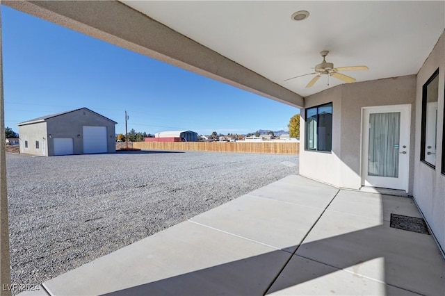 view of patio featuring an outbuilding, a garage, and ceiling fan