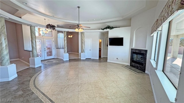 unfurnished living room featuring french doors, light tile patterned floors, a raised ceiling, and ceiling fan