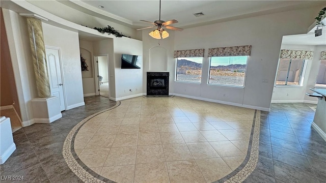 unfurnished living room featuring ceiling fan and light tile patterned flooring